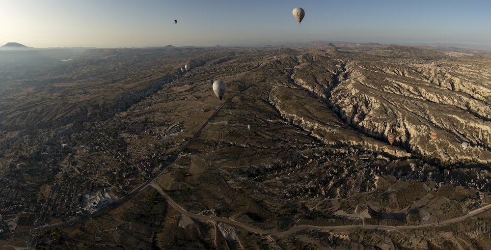 a landscape with a few hot air balloons in the sky