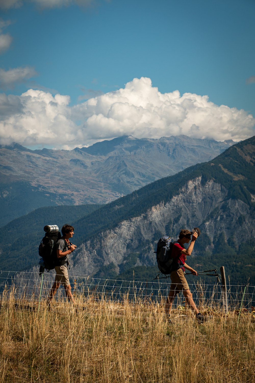 a couple of people taking pictures of a mountain range