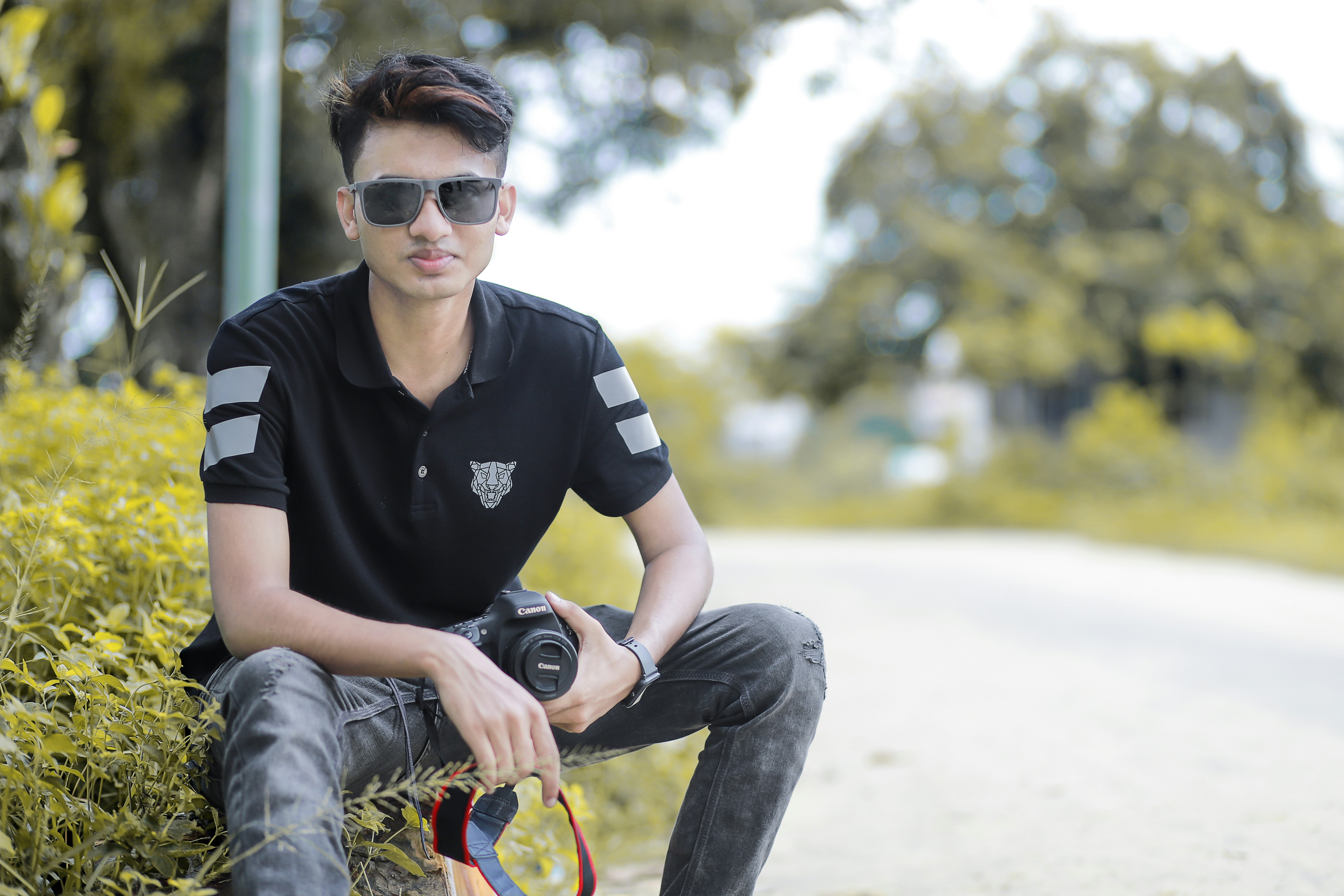 a person sitting on the ground holding a camera