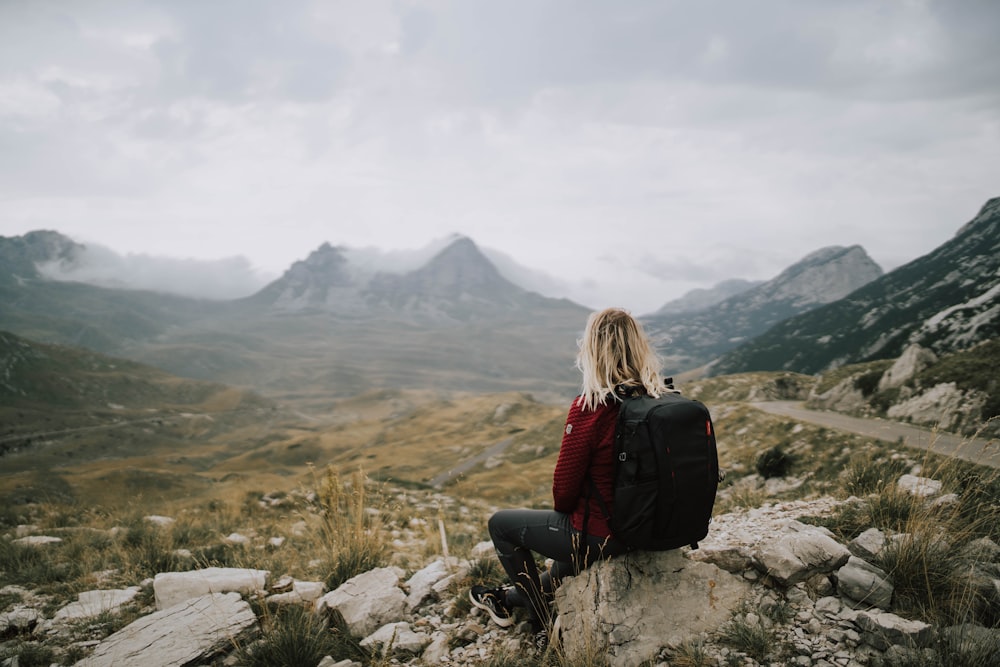 a man sitting on a rock overlooking a valley