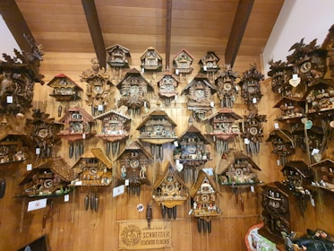 A collection of wooden clocks displayed on a rustic shelf, each with unique glowing epoxy patterns.