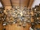 A collection of intricately designed cuckoo clocks displayed on a wooden wall. The clocks vary in size and design, featuring detailed carvings, miniature figurines, and ornate decorations. The setting appears to be a shop or exhibit dedicated to showcasing these traditional timepieces.