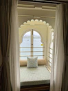 Sitting nook in deluxe suite framed by large window views of Elbasan city.