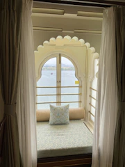 Sitting nook in deluxe suite framed by large window views of Elbasan city.