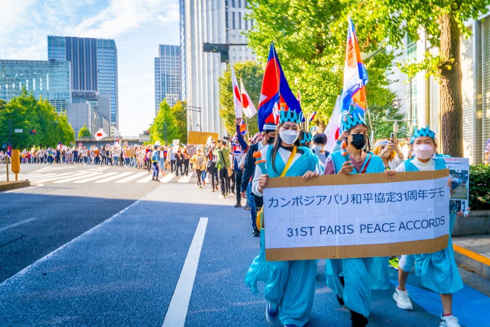 a group of people marching in a parade holding signs and flags