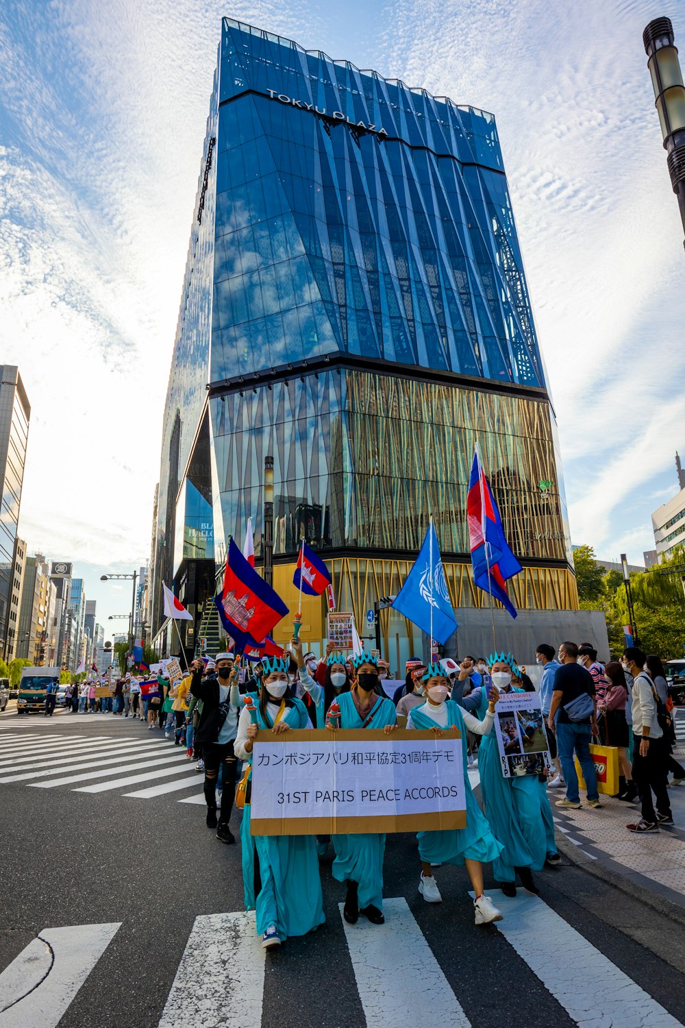 a group of people holding flags and signs in front of a building