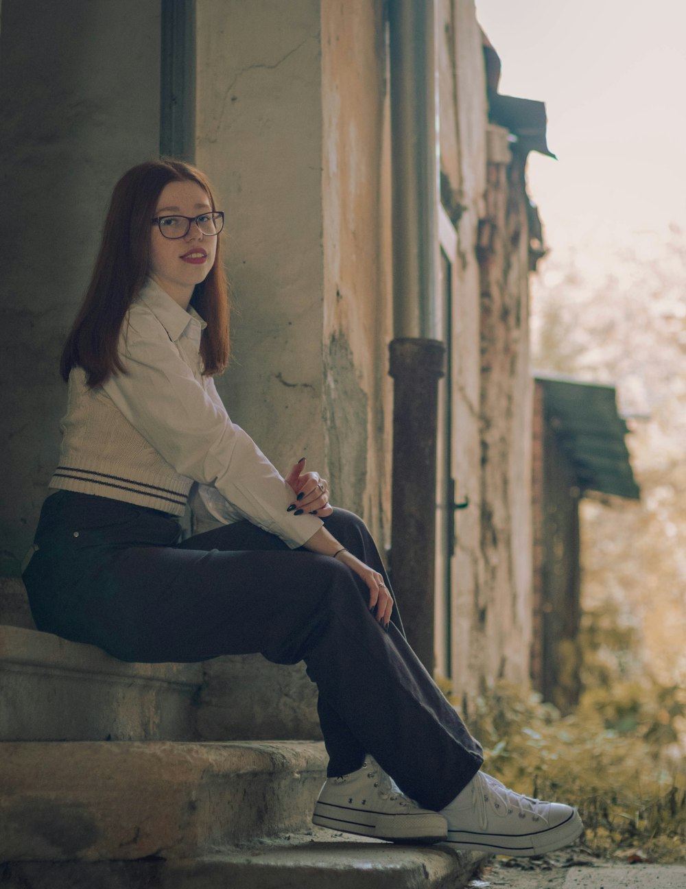 a woman sitting on a stone ledge