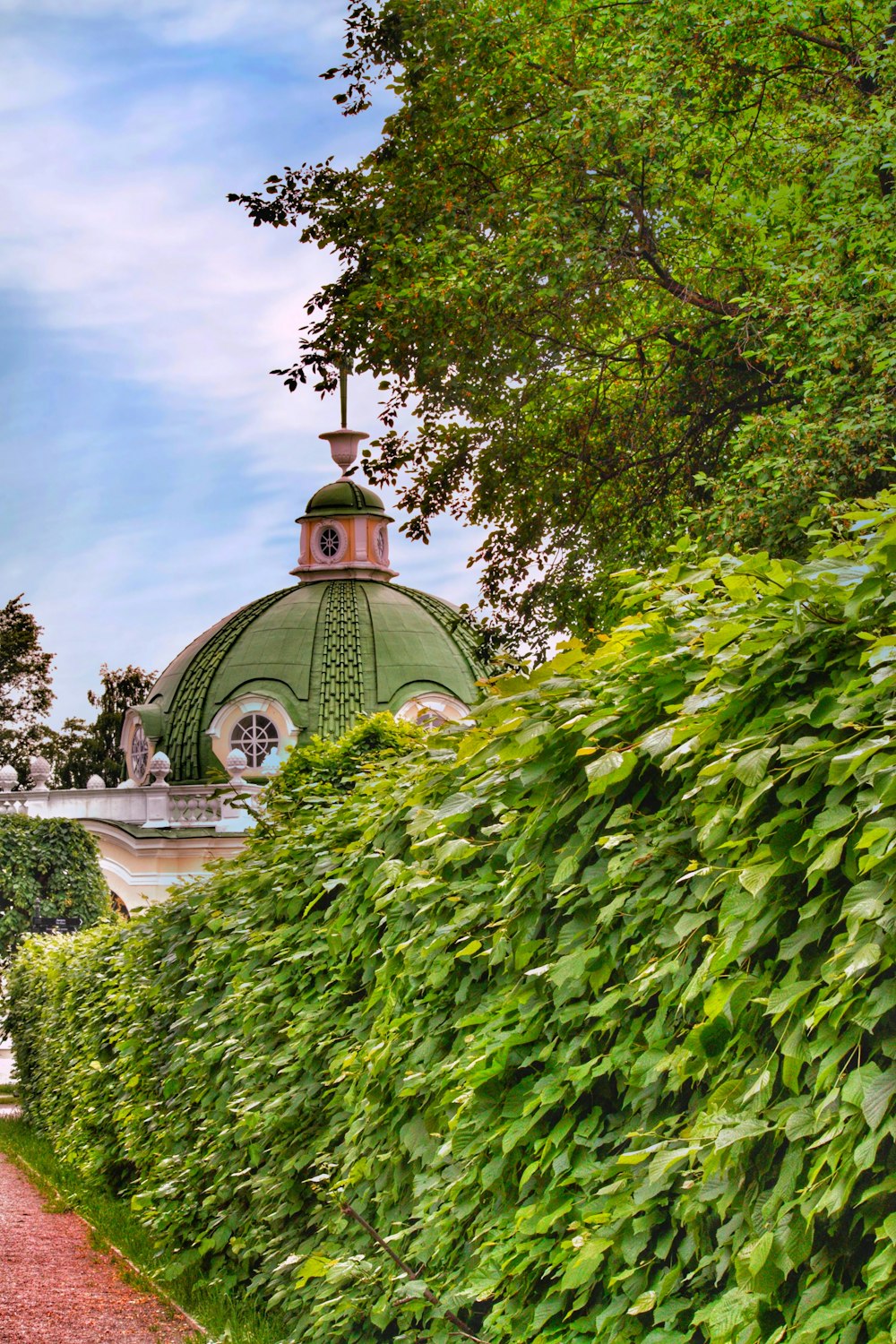 a green dome shaped building surrounded by bushes