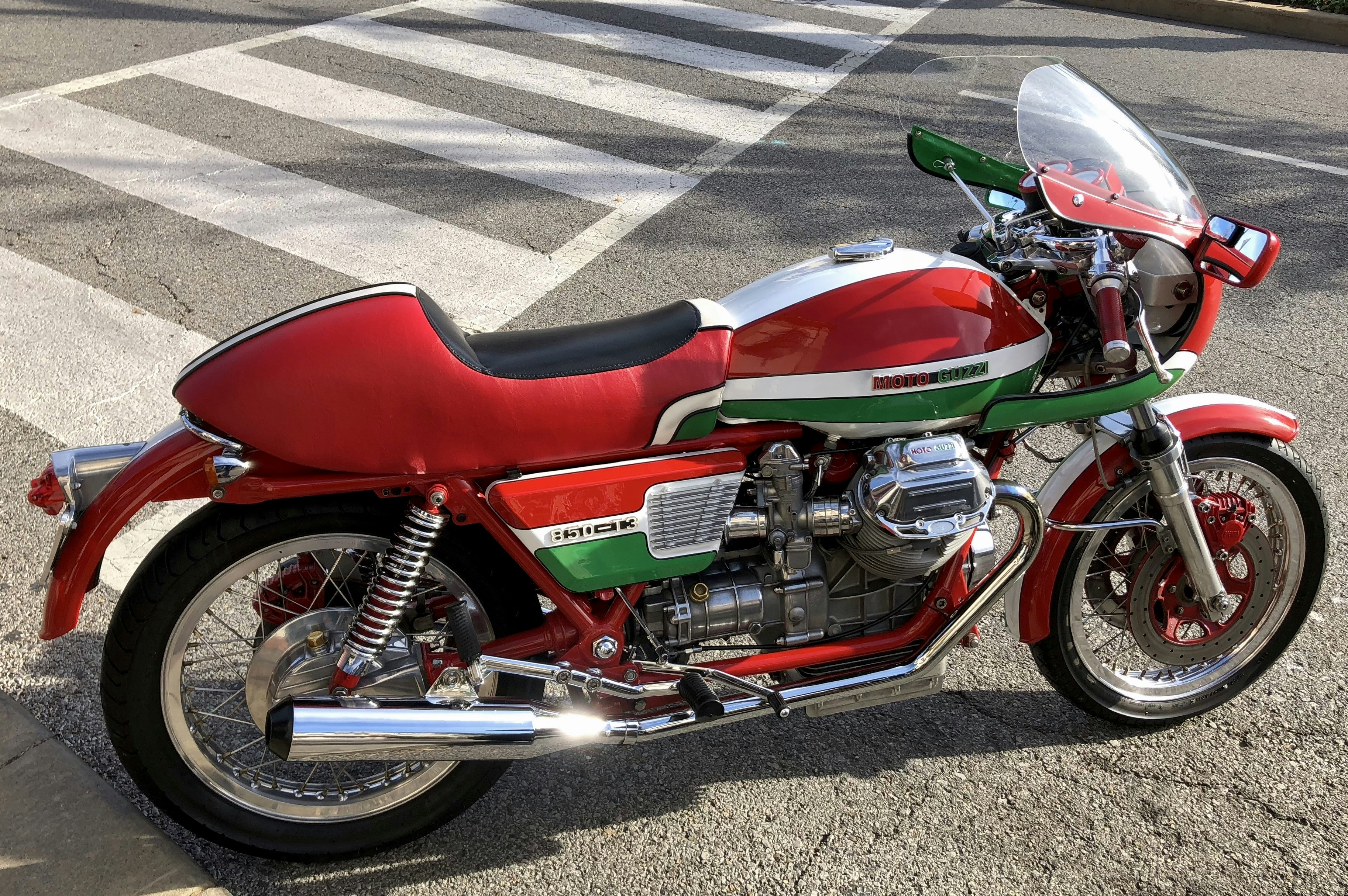 a red motorcycle parked on the side of a road