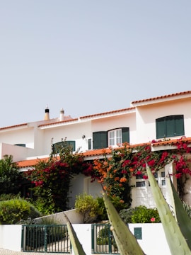 a house with a fence and bushes