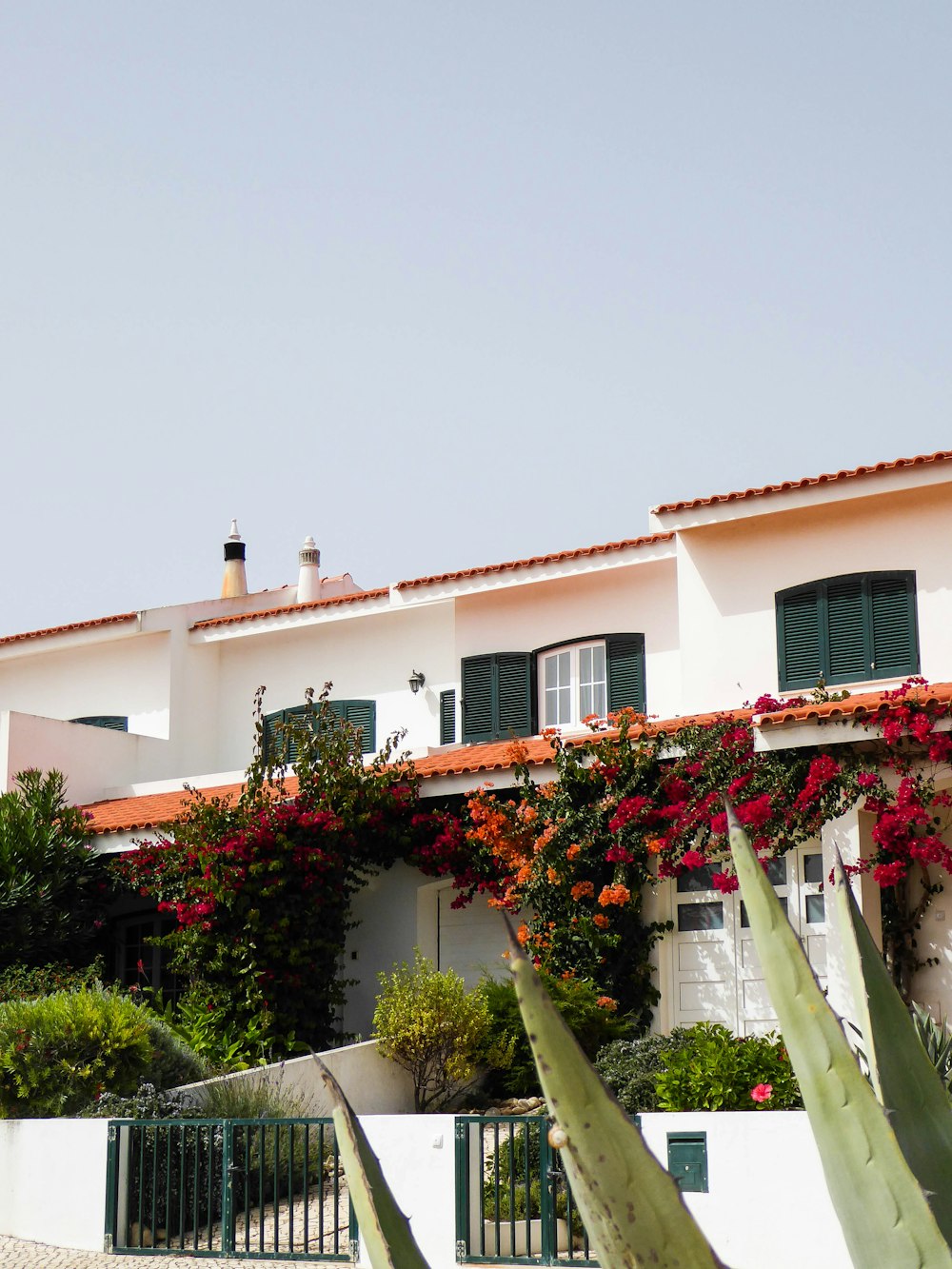 a house with a fence and bushes