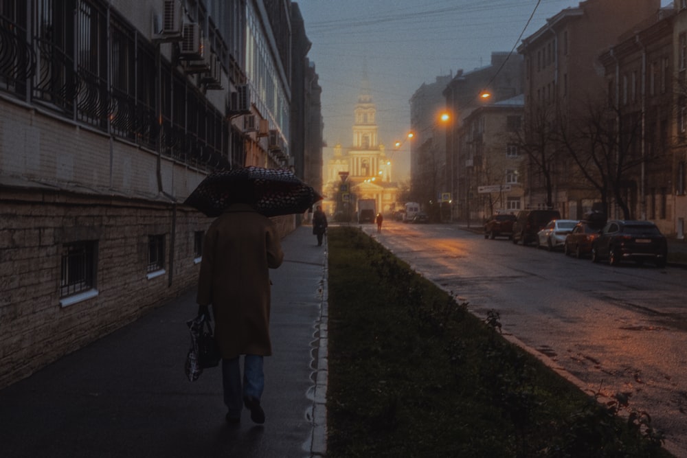 a person walking down a sidewalk with an umbrella