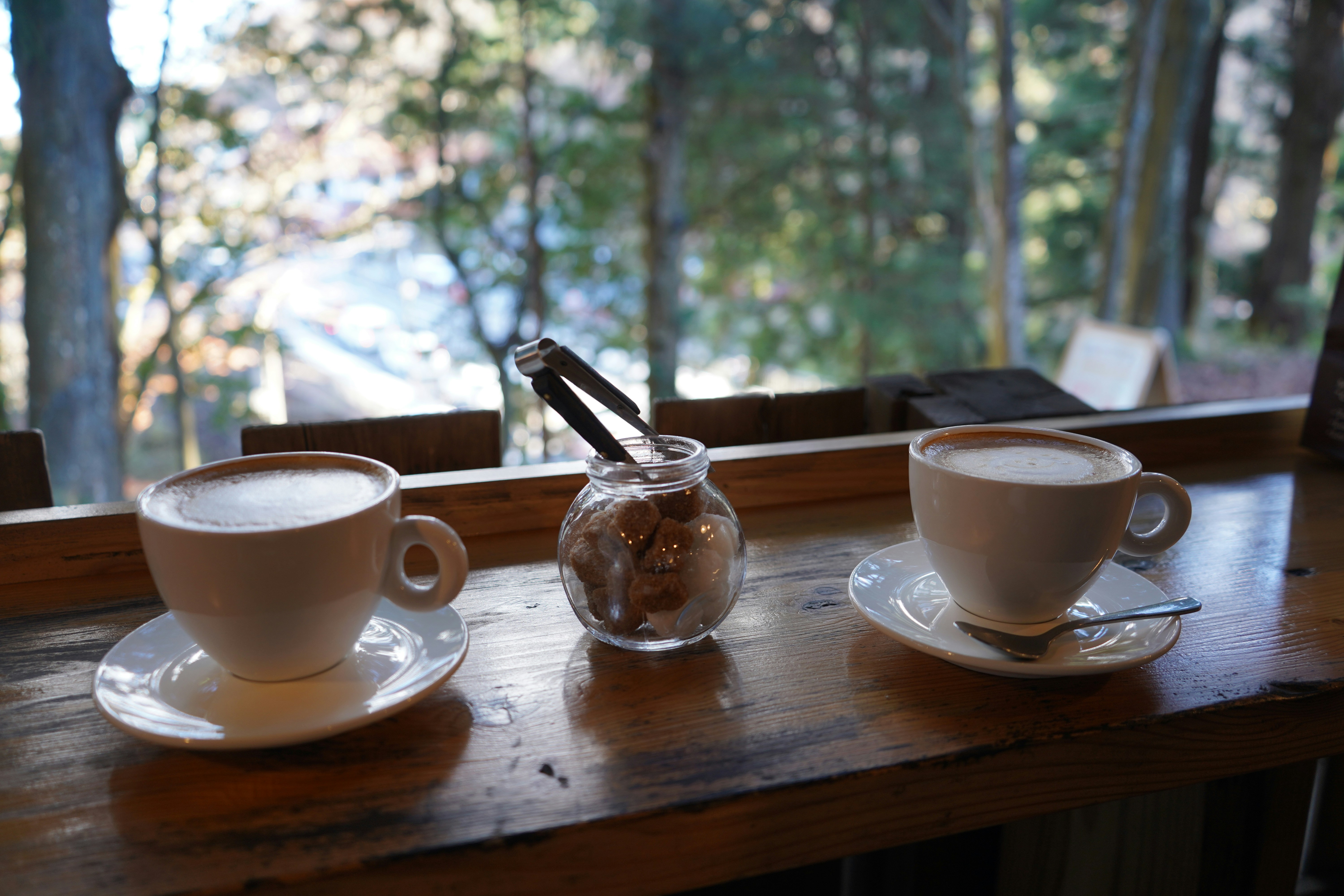 Two cups of cafe latte with sugar in the middle