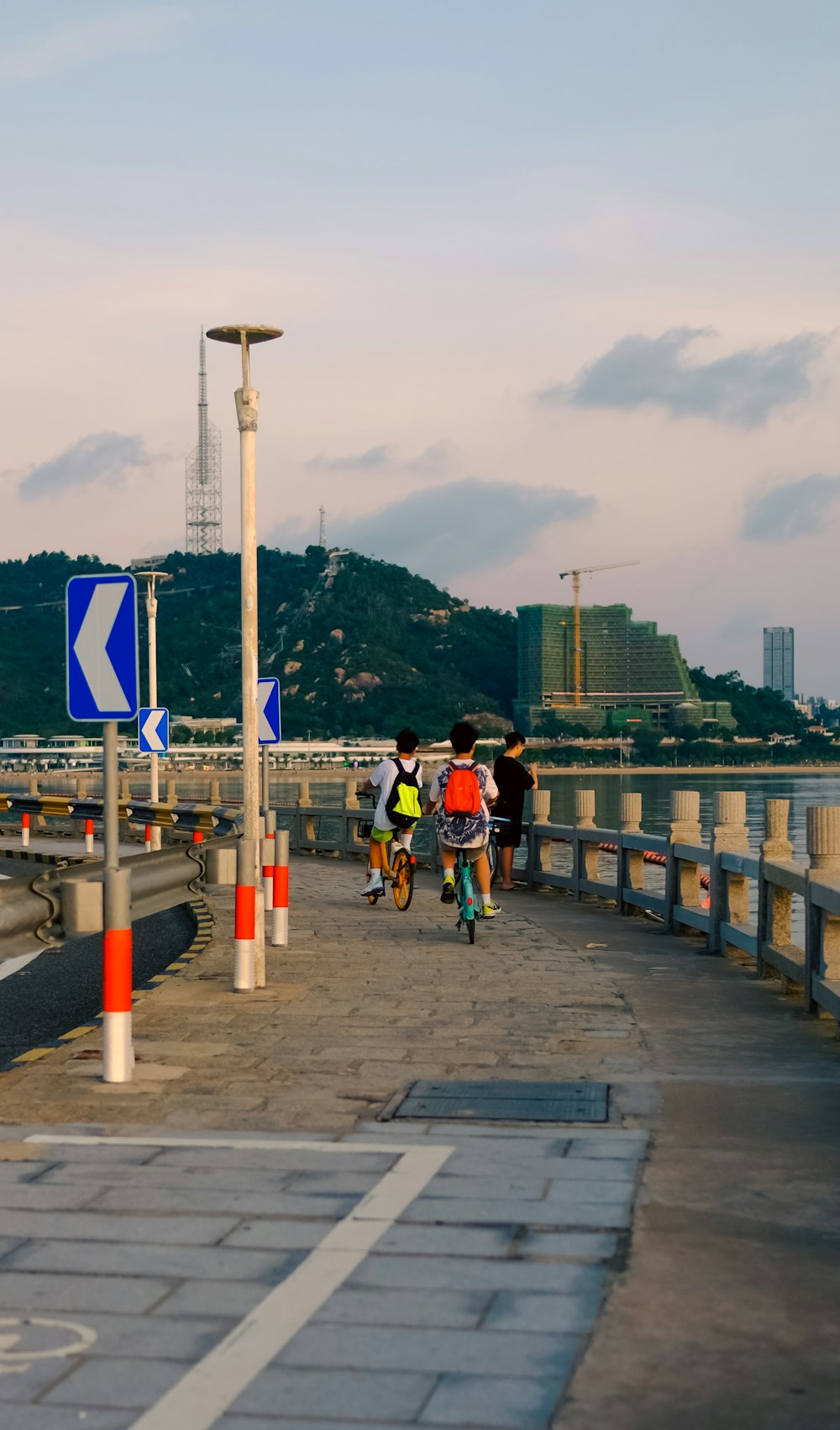 a group of people on a road by a body of water