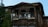 A scenic view of a traditional Batak house surrounded by nature.