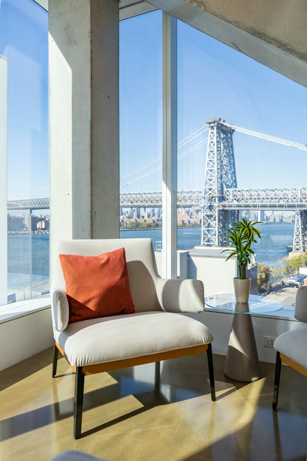 a chair and a table in front of a window overlooking a city