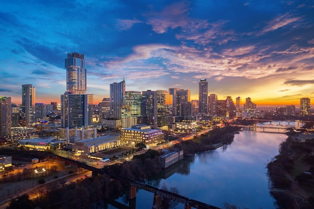 A vibrant photo of Brisbane's city skyline at sunset with the river in the foreground