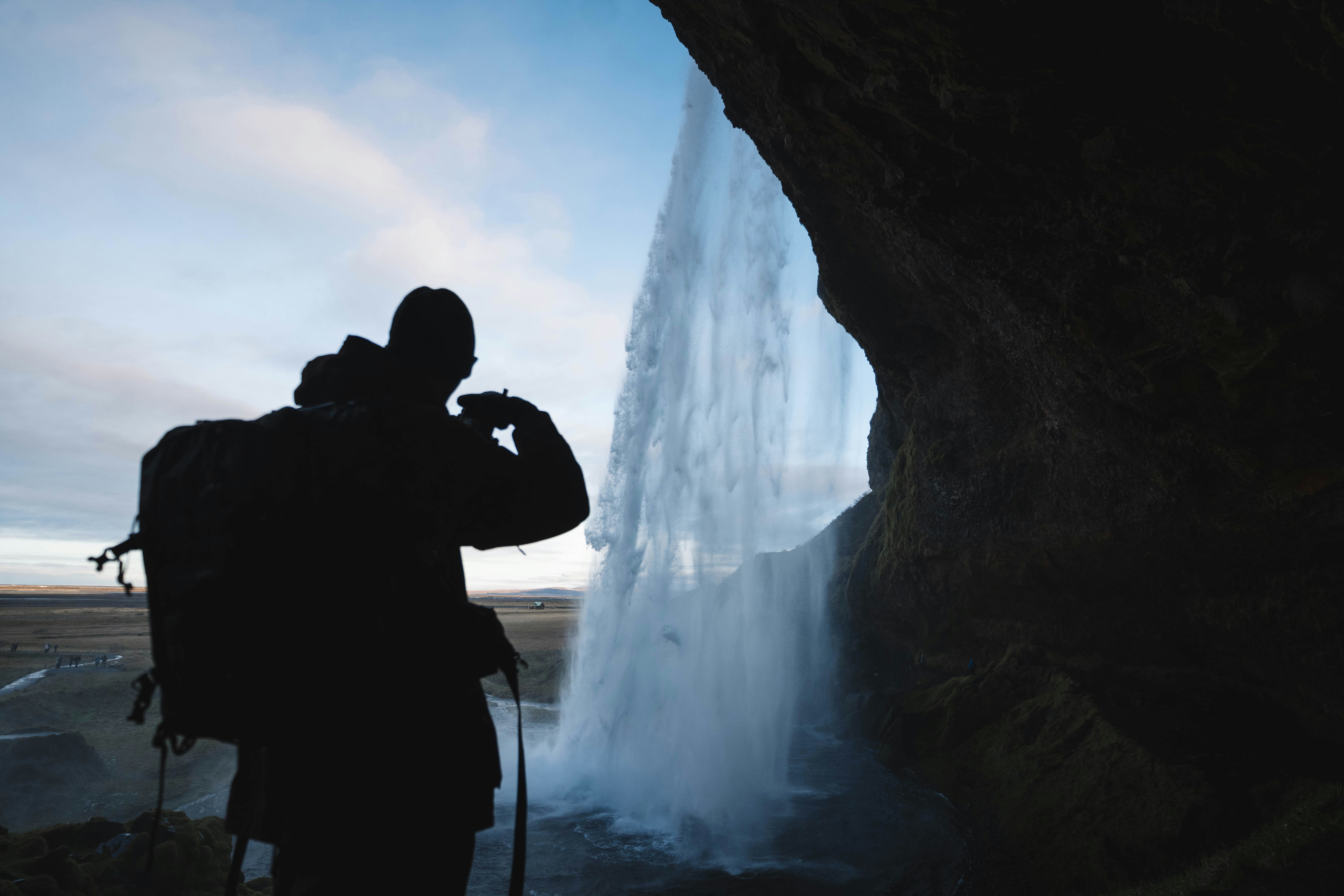 a person taking a picture of a waterfall