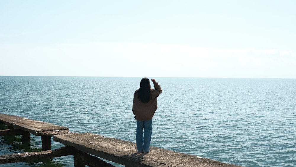 a person standing on a dock looking at the water