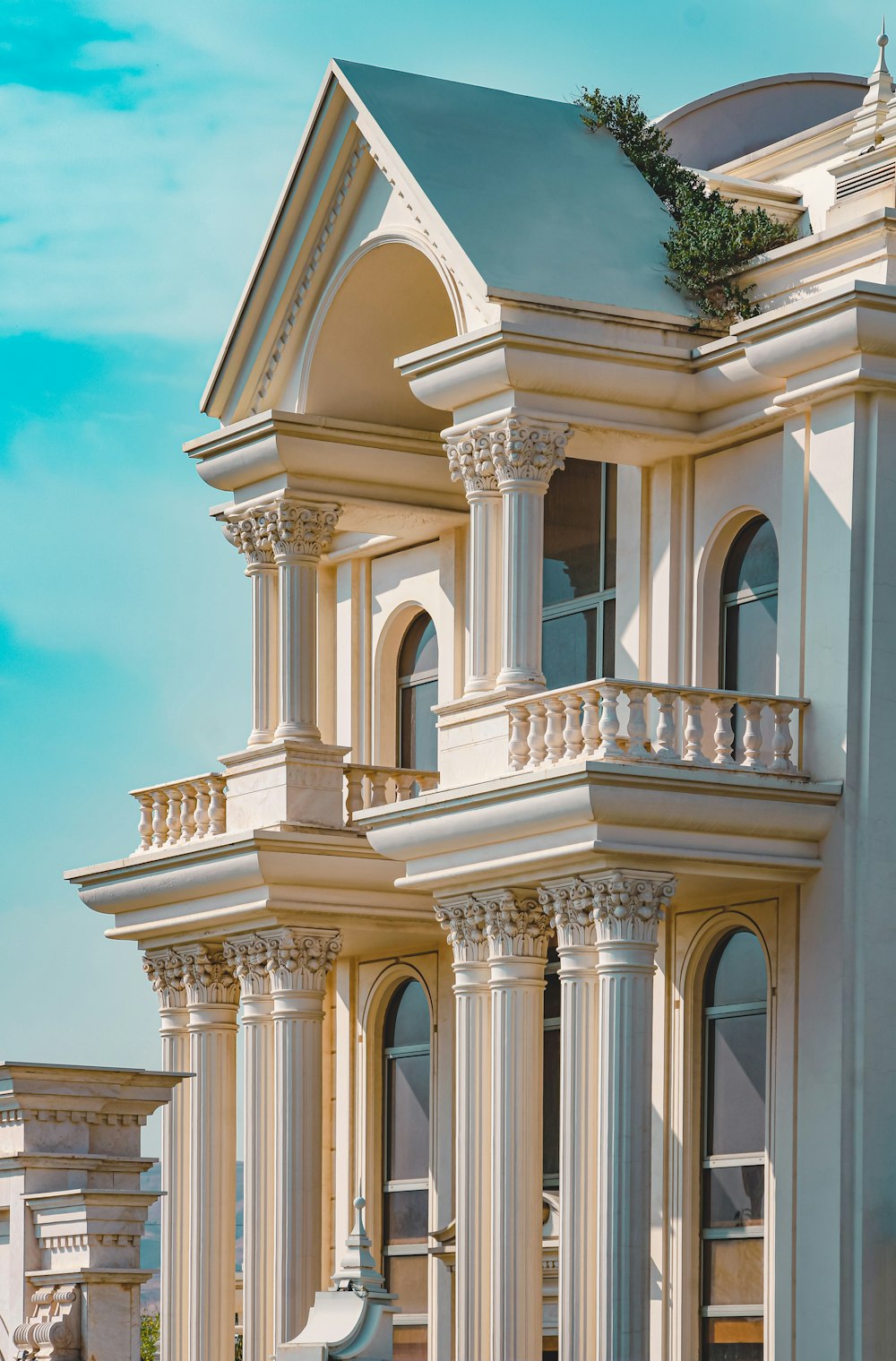 a building with columns and a green roof