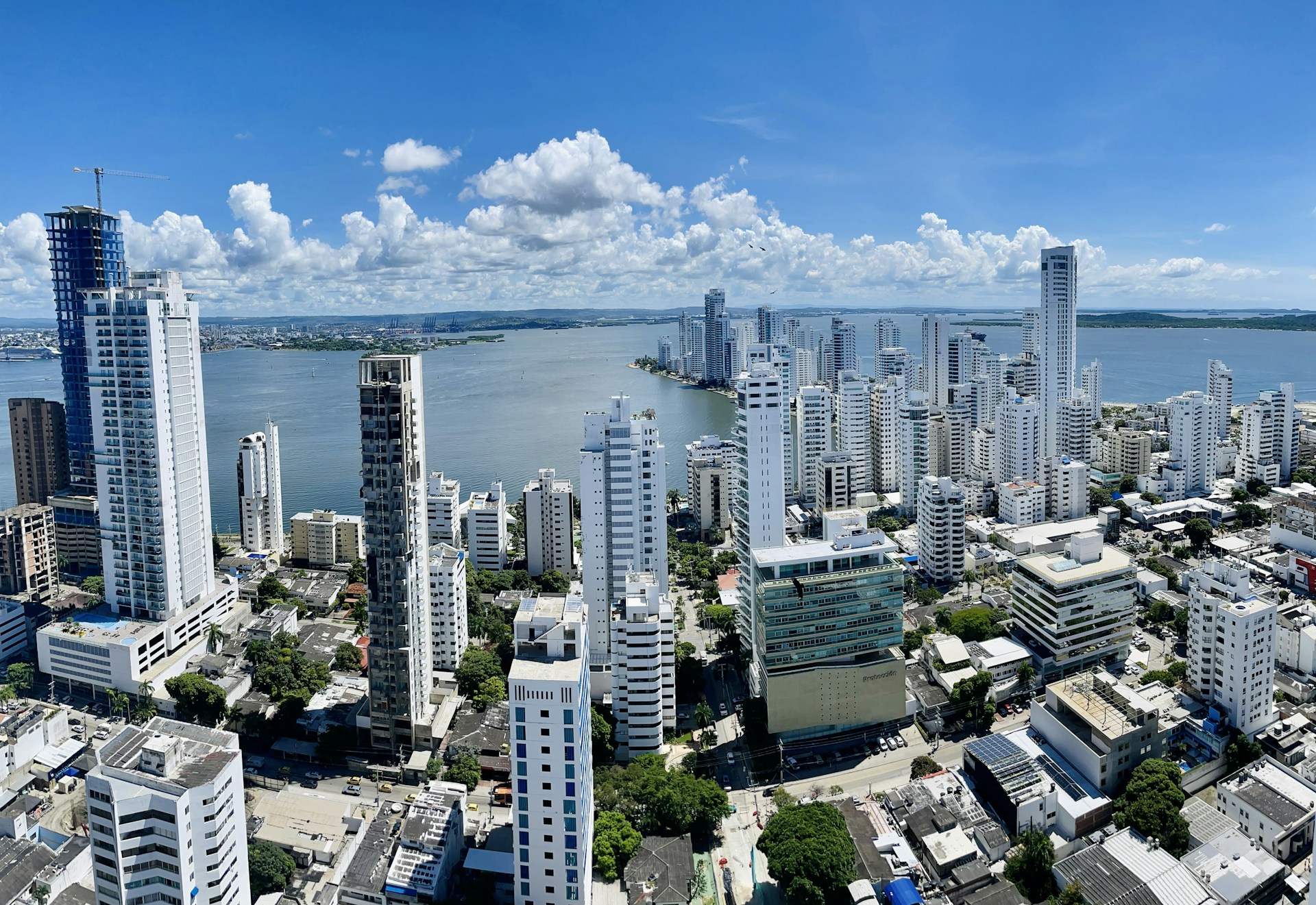 a city with tall buildings and a body of water in the background