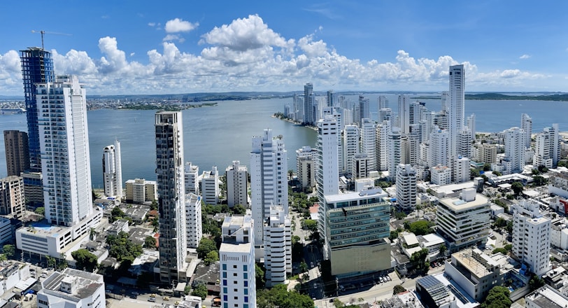 a city with tall buildings and a body of water in the background