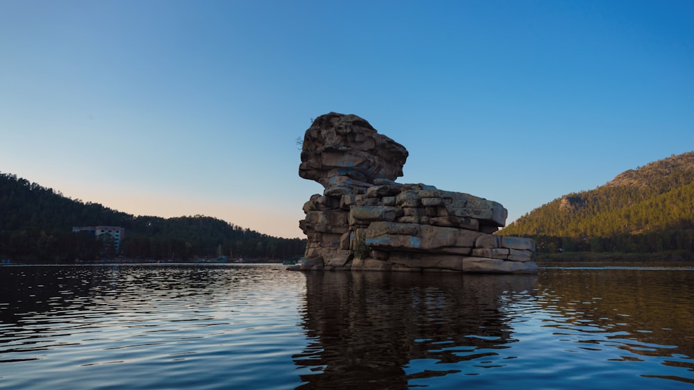 a rock structure in the middle of a body of water