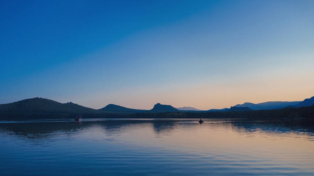 a body of water with mountains in the background