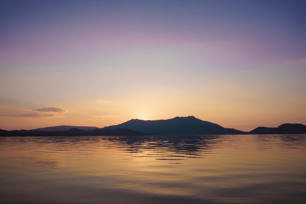 a body of water with hills in the background