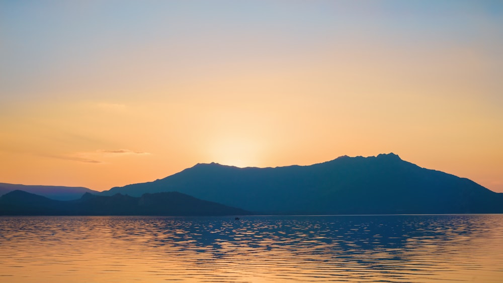 a body of water with hills in the background