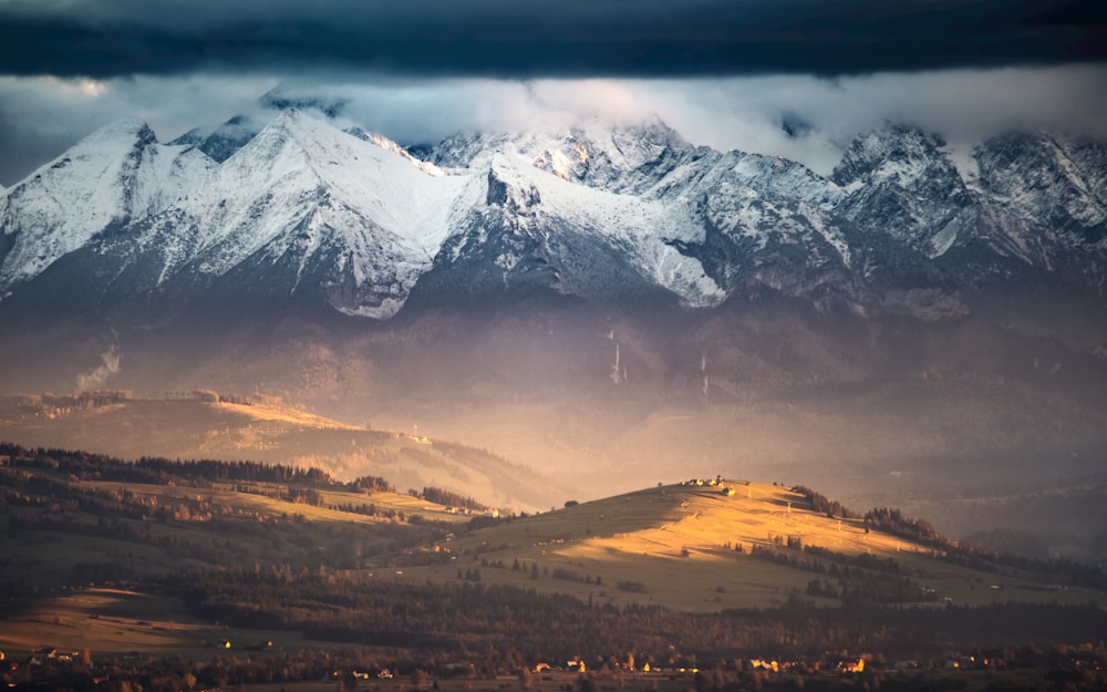 a snowy mountain with a city below