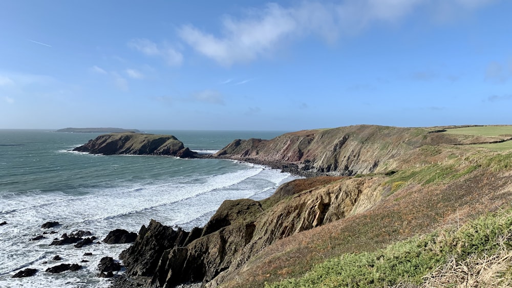 a rocky beach with a large body of water in the background