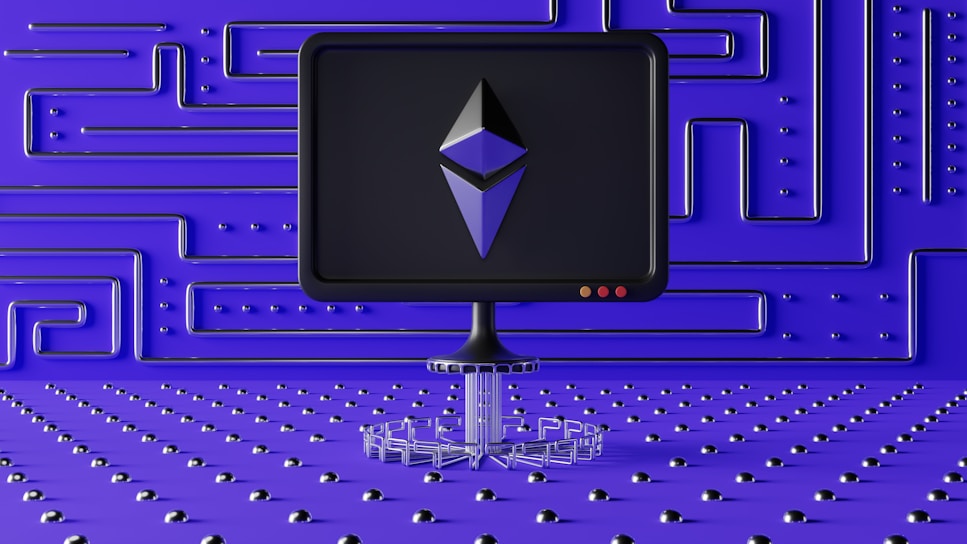 A dark computer screen displays a geometric shape resembling a logo, set against a futuristic blue wall with a maze-like pattern of raised lines and dots. The foreground features a base made of connected hexagons, adding to the high-tech aesthetic.