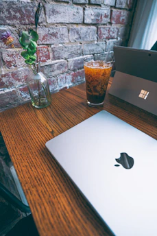 A vibrant close-up of a rustic wooden table adorned with fresh tomatoes, herbs, and a laptop displaying social media analytics.