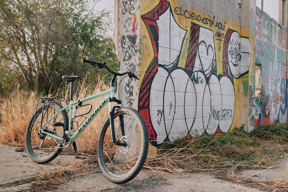 a bicycle parked next to a wall with graffiti