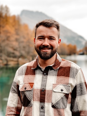 Larry Wolcott smiling outdoors in Denver with mountains in the background.