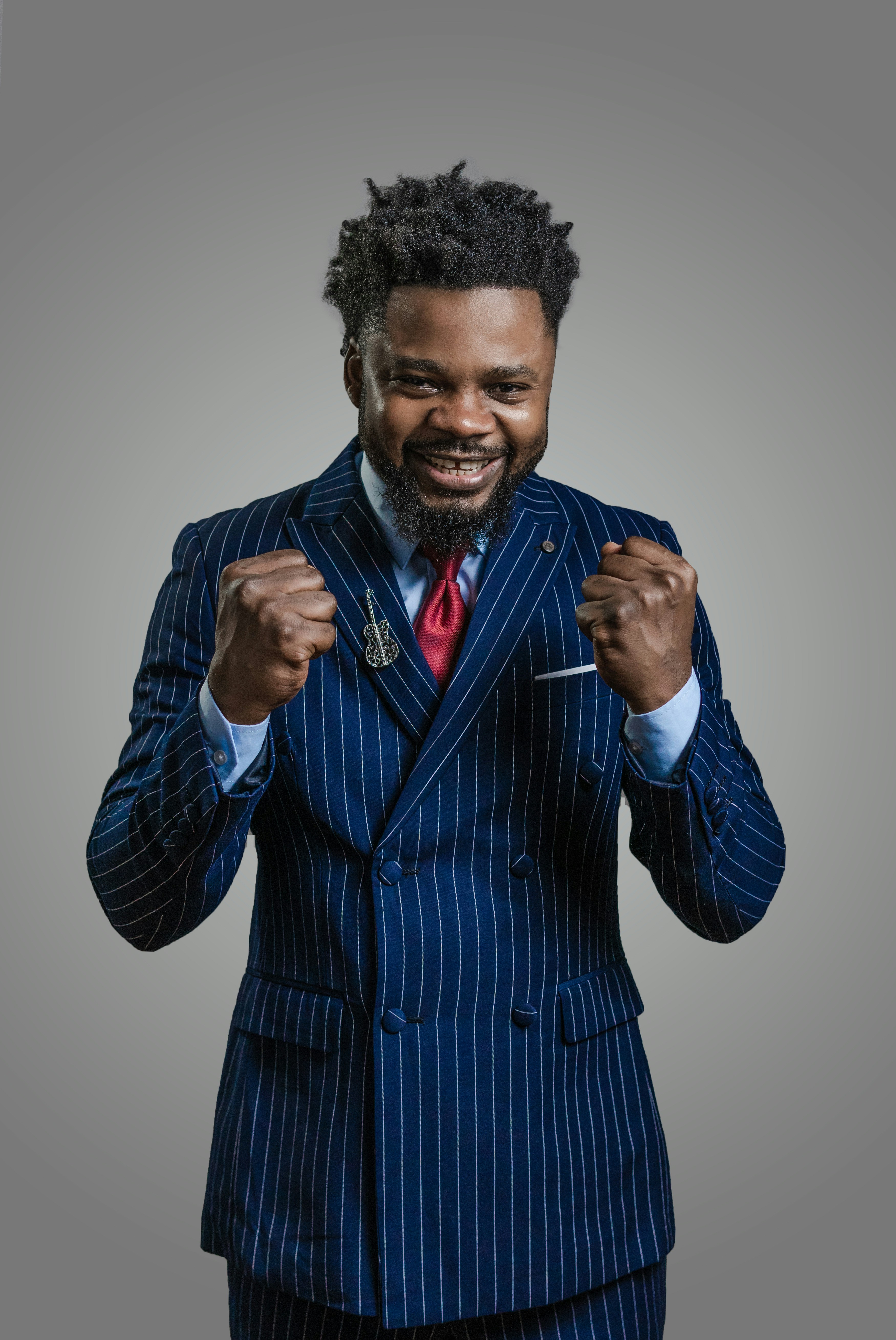 a man with a beard and a blue shirt with his hands on his hips