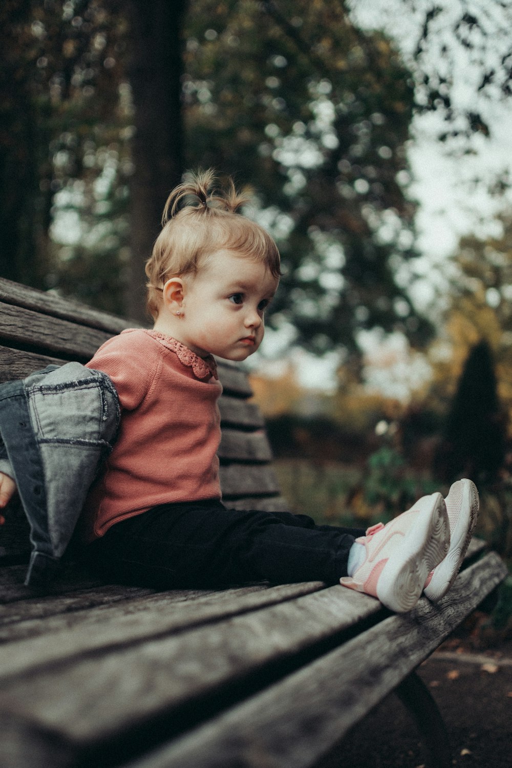 a little girl sitting on a bench