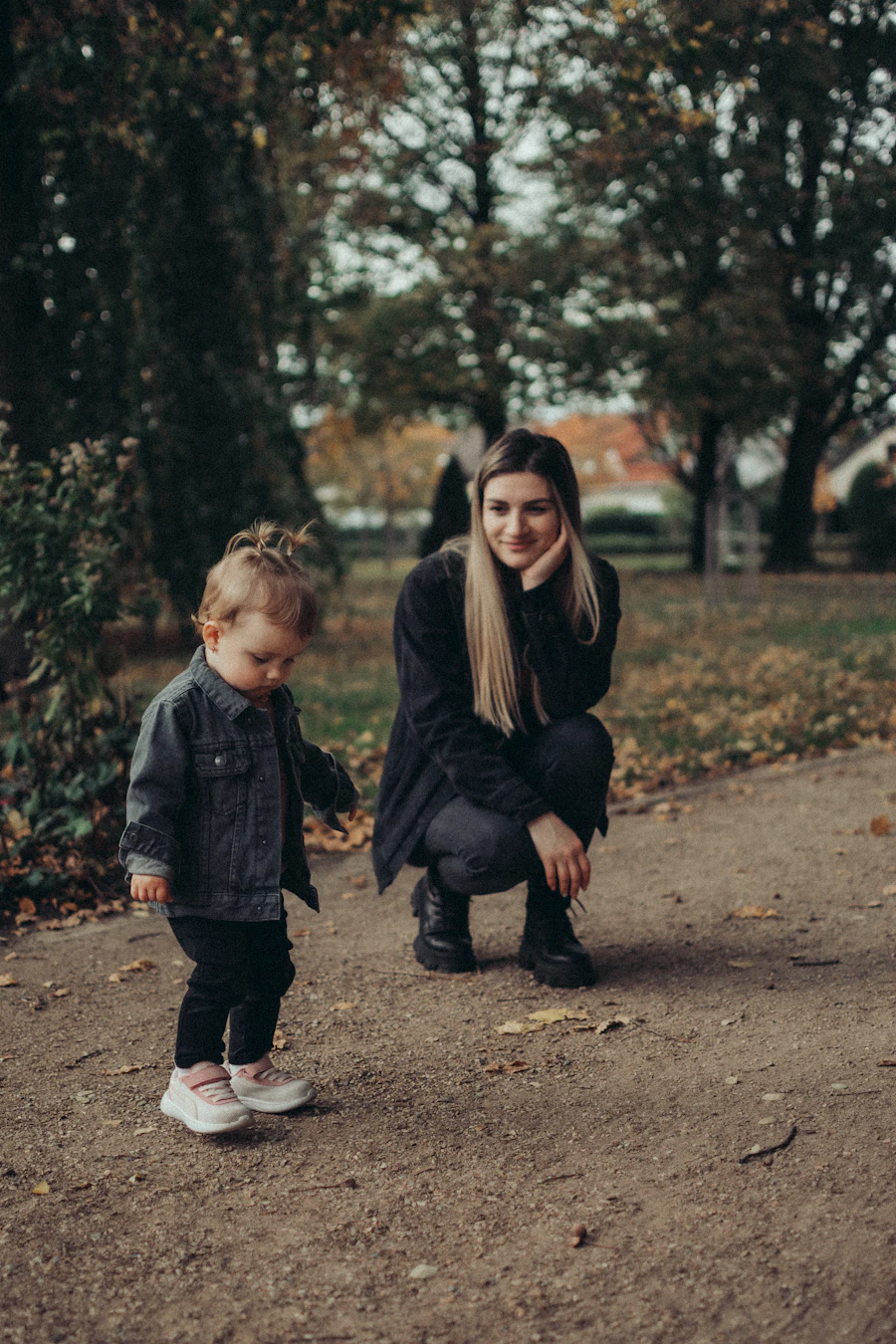 A caregiver and a child walking together on a park path