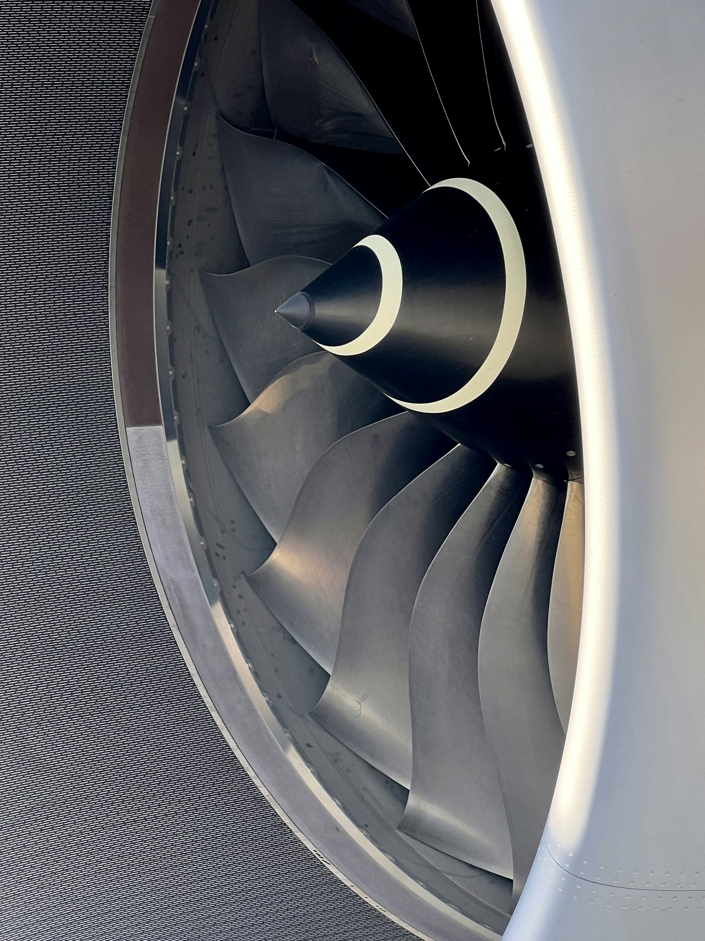 Jet engine turbine blades close-up, dark metallic surfaces, dramatic industrial lighting, moody atmosphere
