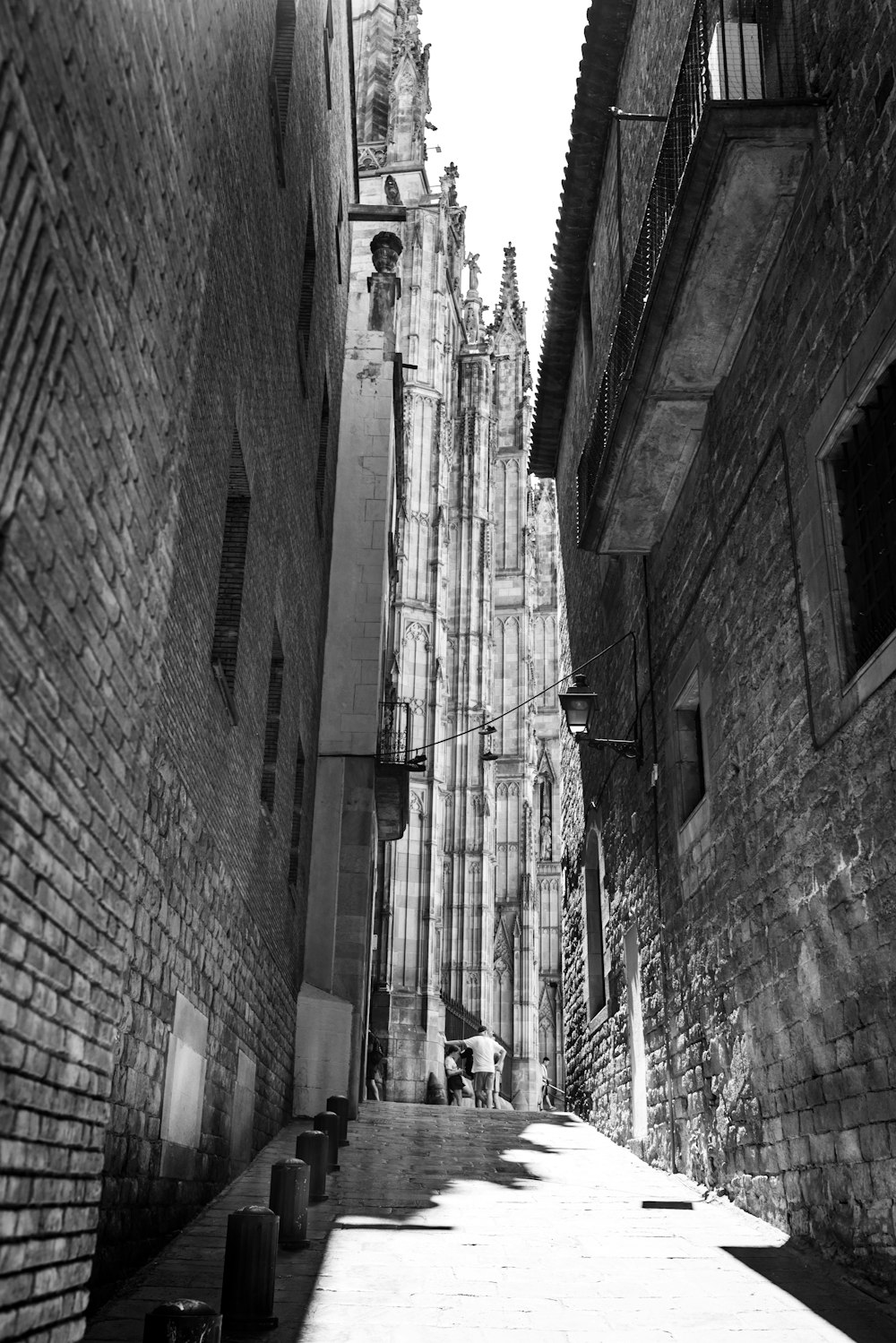 a couple of people walking down a street between buildings