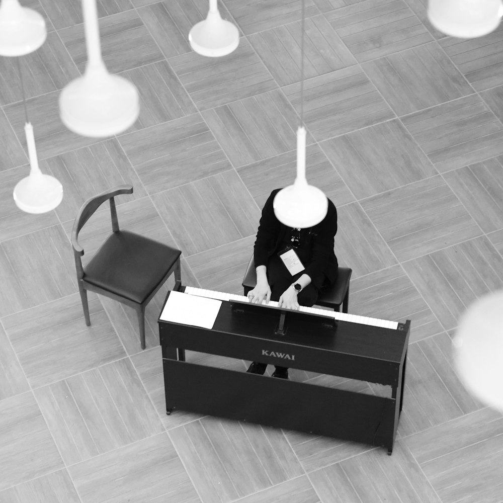 a person sitting at a desk with a lamp on top of it