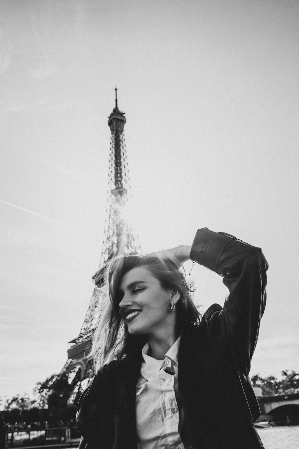 a person smiling in front of a tall metal tower