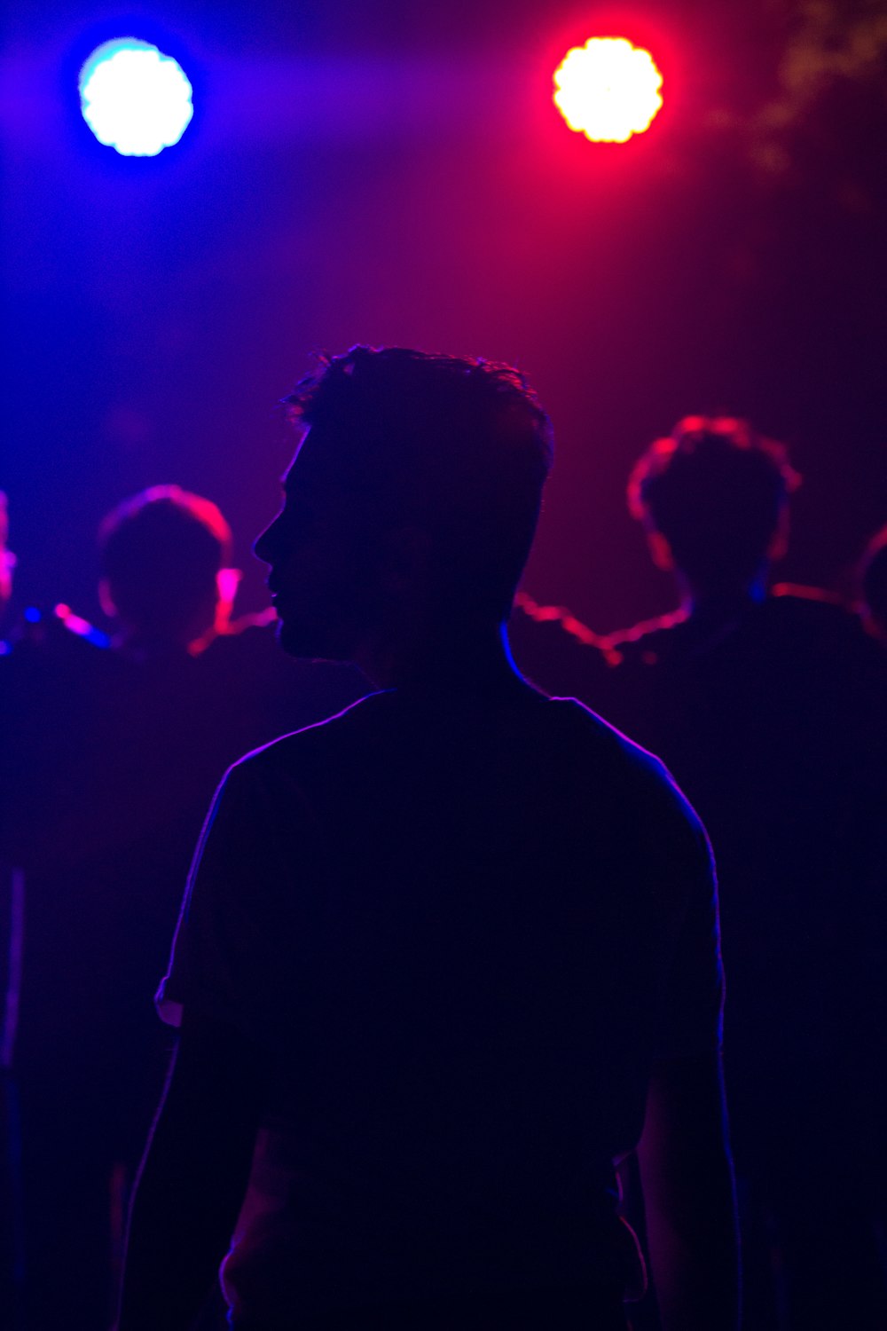 a group of people in a dark room with bright lights