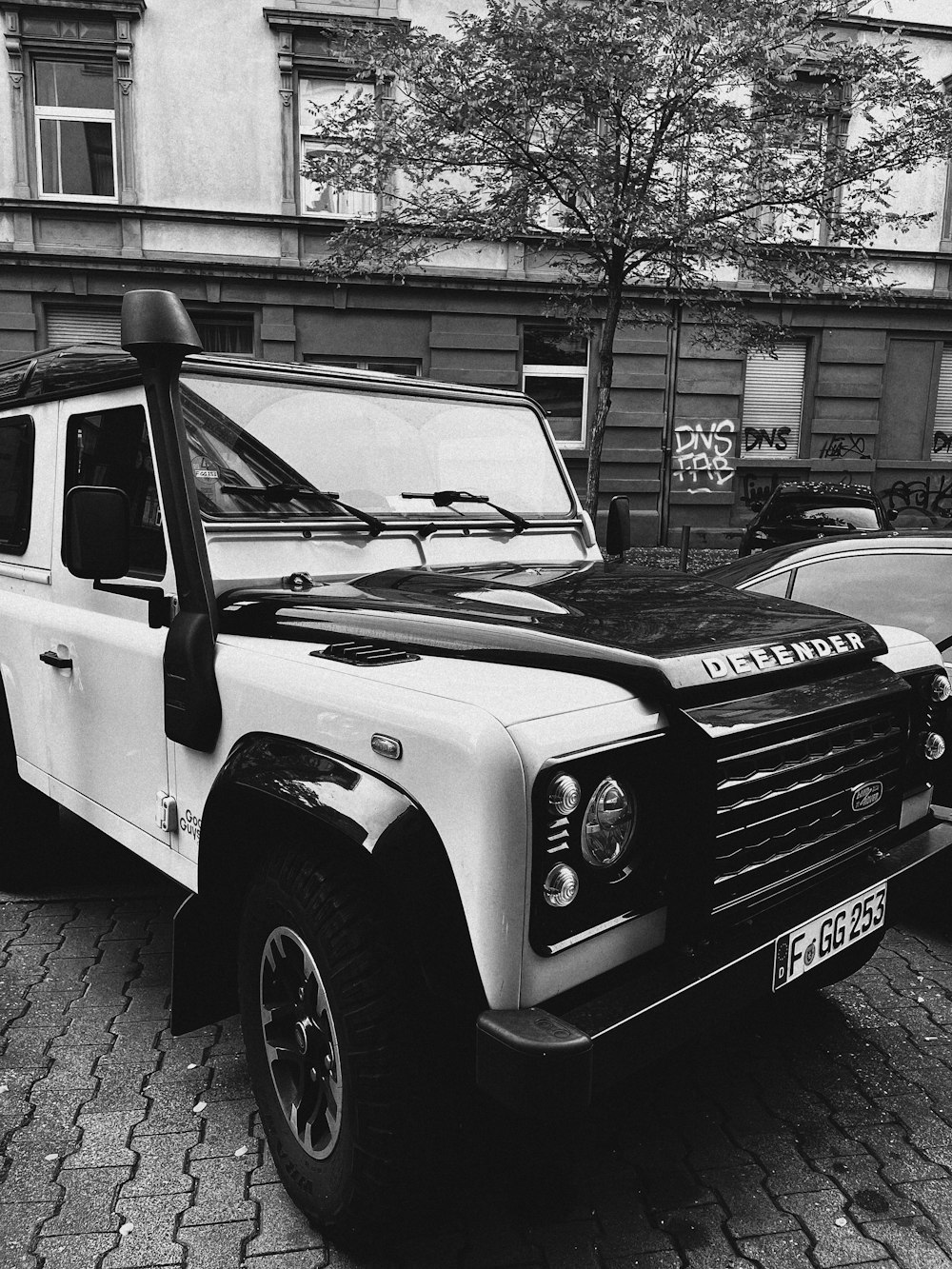 a black and white photo of a truck parked on a street