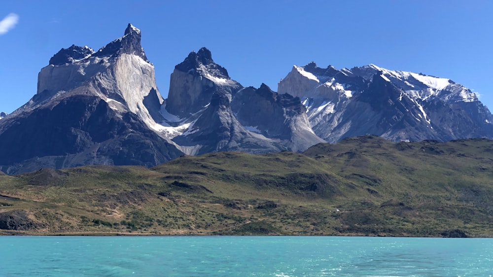 a body of water with mountains in the back with Torres del Paine National Park in the background
