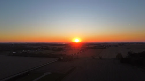 Wide shot of a calm landscape under a fading sunset sky.