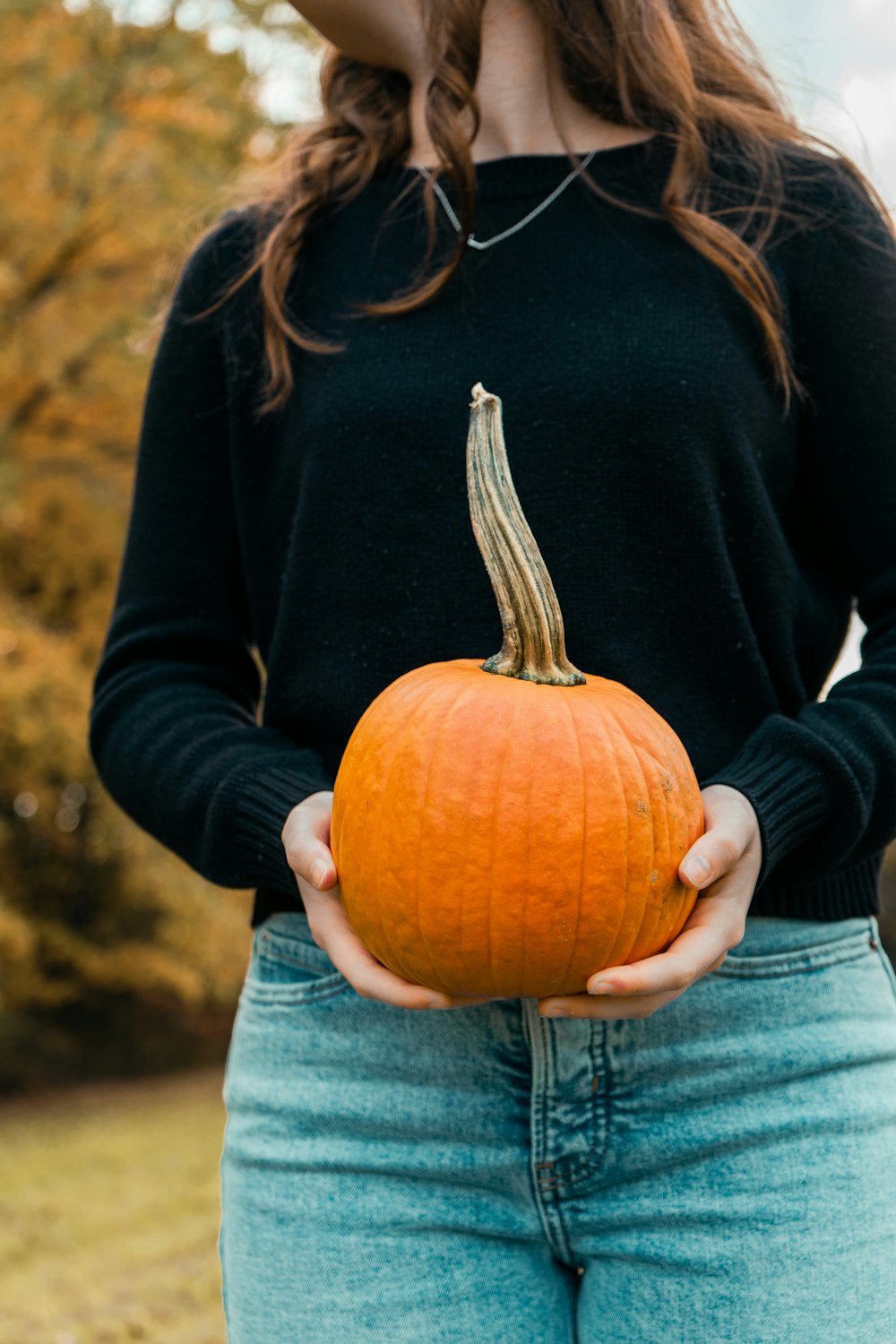 a woman holding a pumpkin