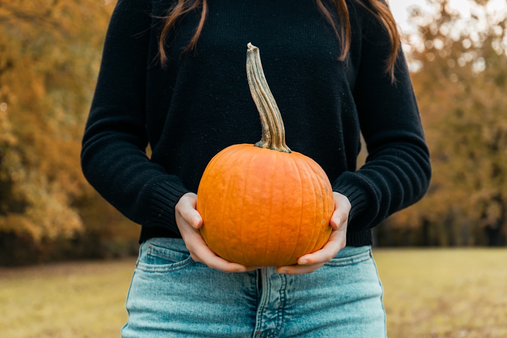 a woman holding a pumpkin