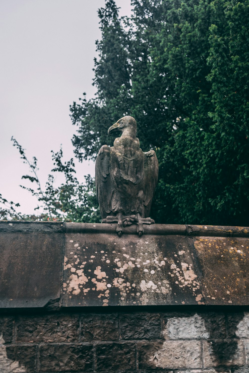 Una estatua de un pato en una pared de ladrillo